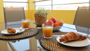 A breakfast setting with croissants, juice, and fruit on a table with a view. - C7 - 3 Bed Luxury Penthause by DreamAlgarve (Lagos)
