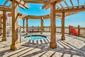 A wooden deck with a hot tub, a wooden pergola, and a view of the beach. - On the Beach - First responders, Medical/Military discounts (destin)