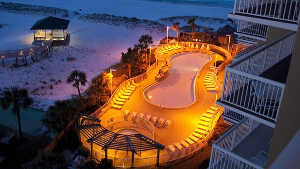 Un resort con piscina, playa y balcones frente al mar.
