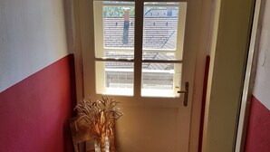 A room with a door leading to a balcony, a small table with a vase, and a patterned rug. - Vila Koman (Jezersko)
