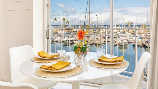 Mesa de comedor para dos con vista a un puerto deportivo.