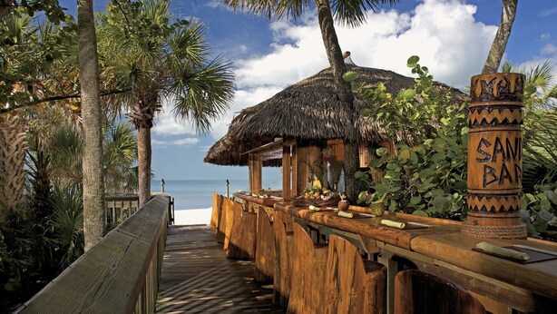 A wooden deck leading to a thatched-roof bar area with a view of the ocean. - Walk to Vanderbilt Beach, Pets, 2 Mstrs w Kings beds, htd pool, bikes, BBQ (North Naples)