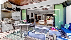 An open-plan living space with a kitchen, dining area, and seating area. - Walk to Vanderbilt Beach, Pets, 2 Mstrs w Kings beds, htd pool, bikes, BBQ (North Naples)