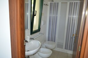 Un baño con inodoro, bidé y lavamanos.
