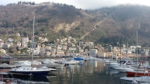 A marina with boats docked, a hillside with buildings, and a mountainous backdrop. - L'Approdo di Sant'Agostino (Como)