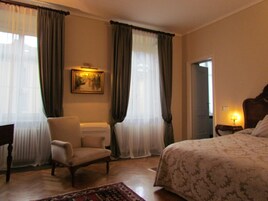Habitación de hotel con cama, una silla, un escritorio y un cuadro en la pared.