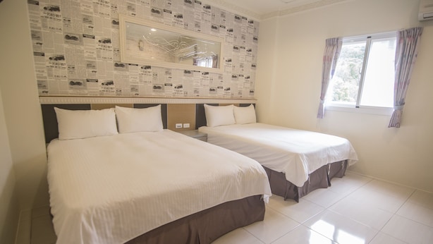 A hotel room with two beds, a large mirror, and a window with curtains. - SouthSea B&B (Liuqiu)
