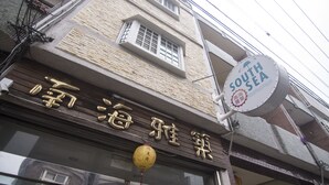 A building with a sign that reads "South Sea" and another sign with Chinese characters. - SouthSea B&B (Liuqiu)