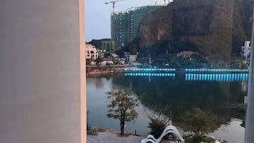 A view of a waterfront area with a construction site, a bridge, and a pedestrian walkway.