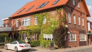 A traditional brick building with a red-tiled roof, a sign reading "Ritta's," and a white car parked in front. - Rüter's Hotel & Restaurant (Salzhausen)
