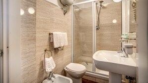 Une salle de bain moderne avec une douche à parois de verre, un lavabo et des toilettes.