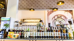 Un espace bar avec une variété de bouteilles et une personne qui travaille derrière le comptoir.