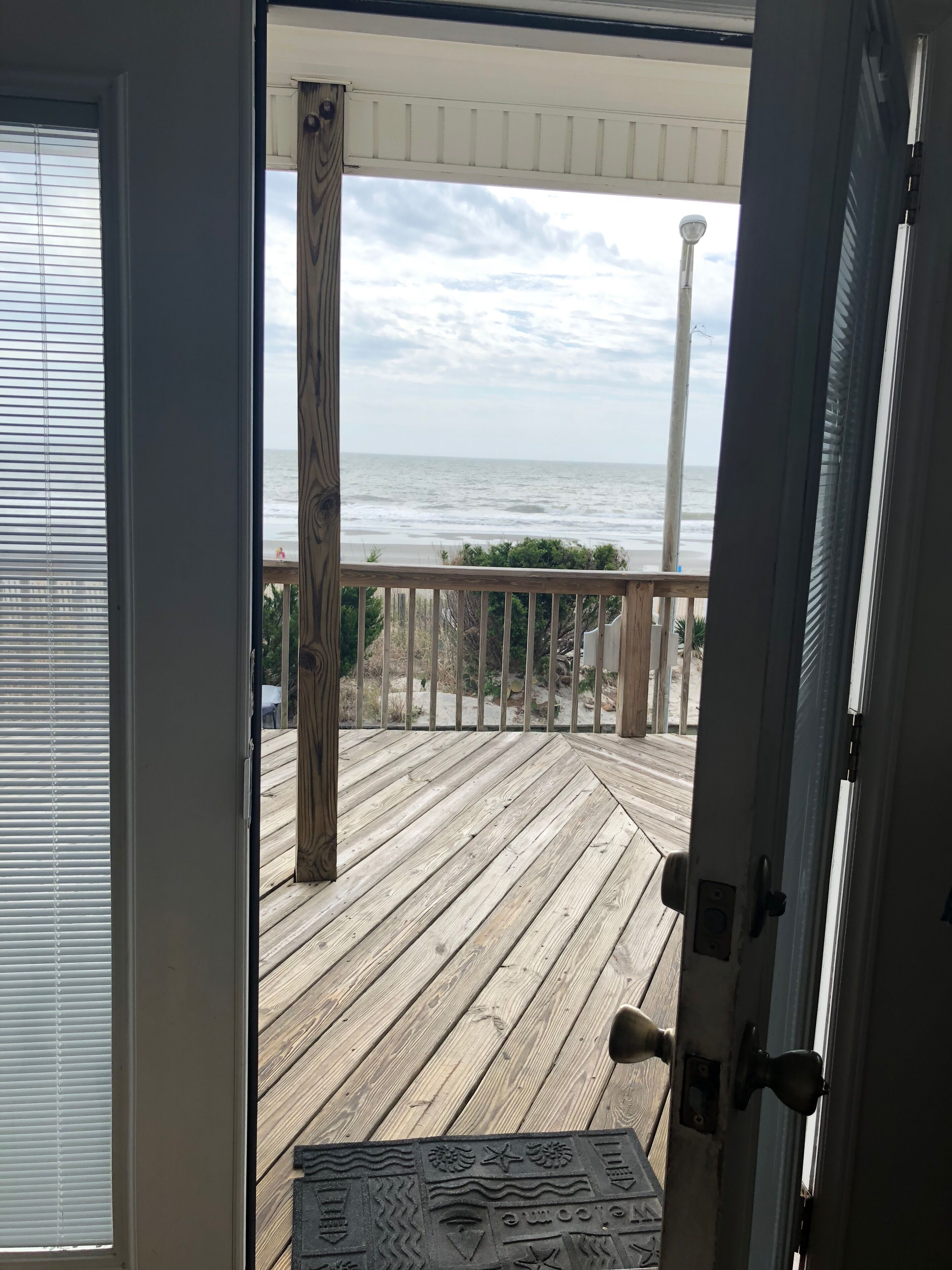 Eine Holzterrasse mit Blick auf den Ozean.