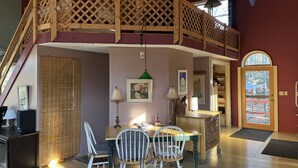 A cozy dining area with a wooden table, two chairs, and a ceiling fan.