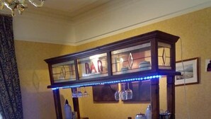Een bar met houten meubels, een toonbank en een bord waarop 'BAR' staat.