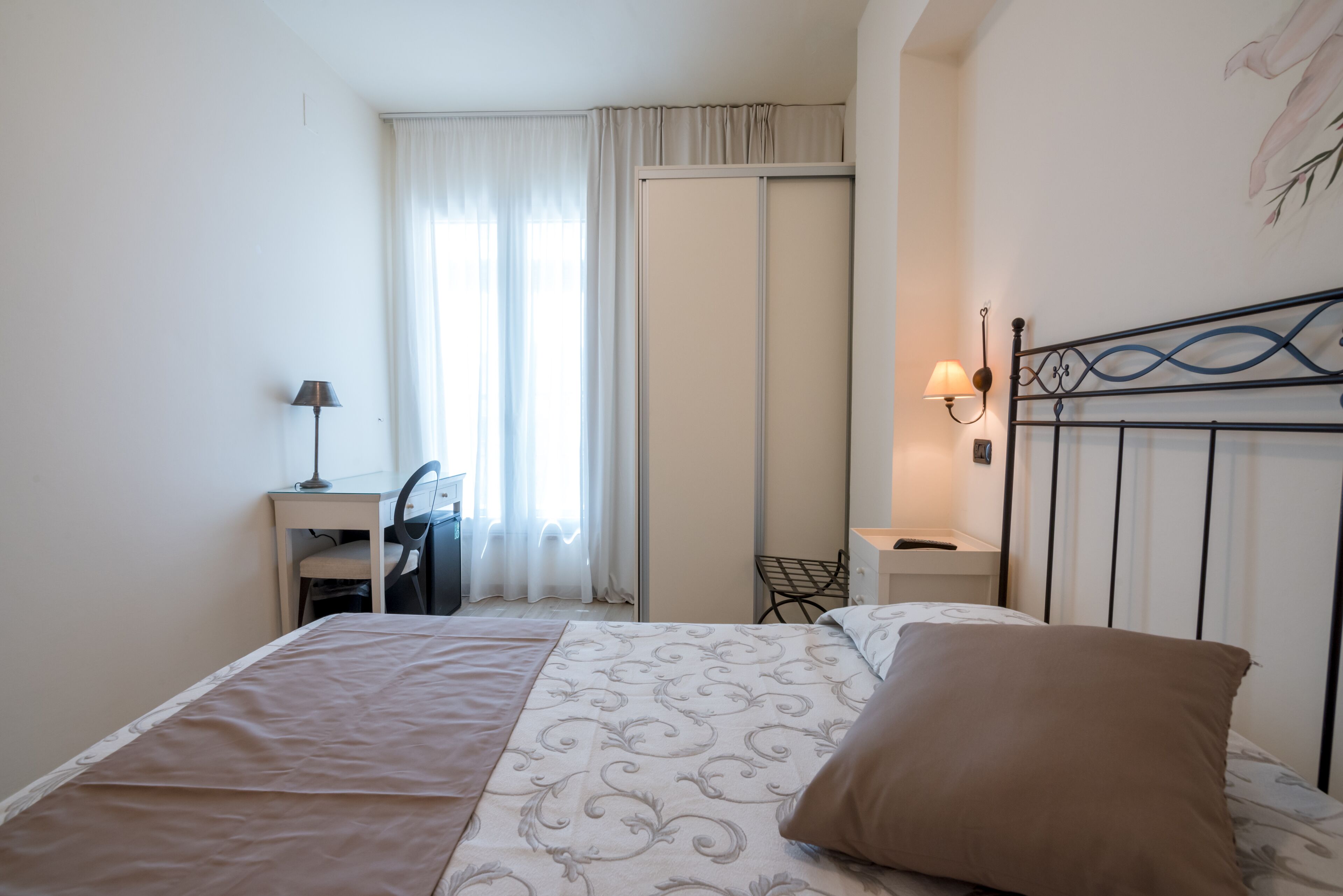 Un dormitorio con cama, escritorio y silla.
