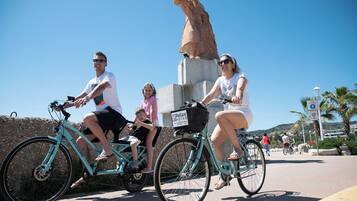 A group of people on bicycles with a statue in the background.