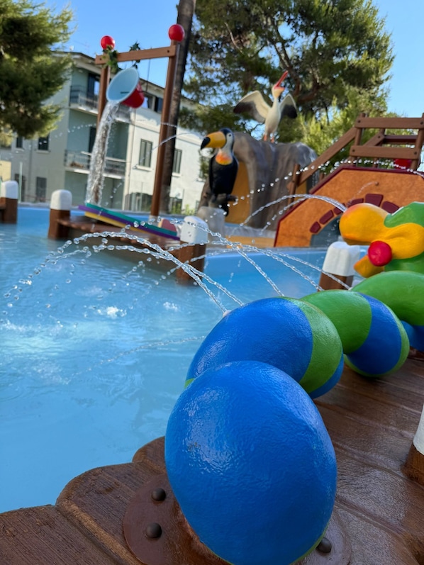 A water play area with a wooden deck and colorful balls.