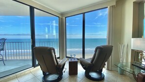 Una habitación con dos sillones de cuero orientados a un ventanal con vista al mar.