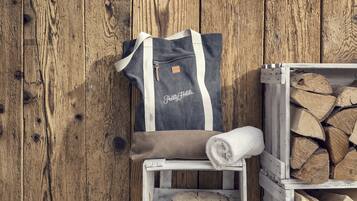 A wooden wall, a grey and white bag with "Pretty Hotels" text, and a stack of firewood.