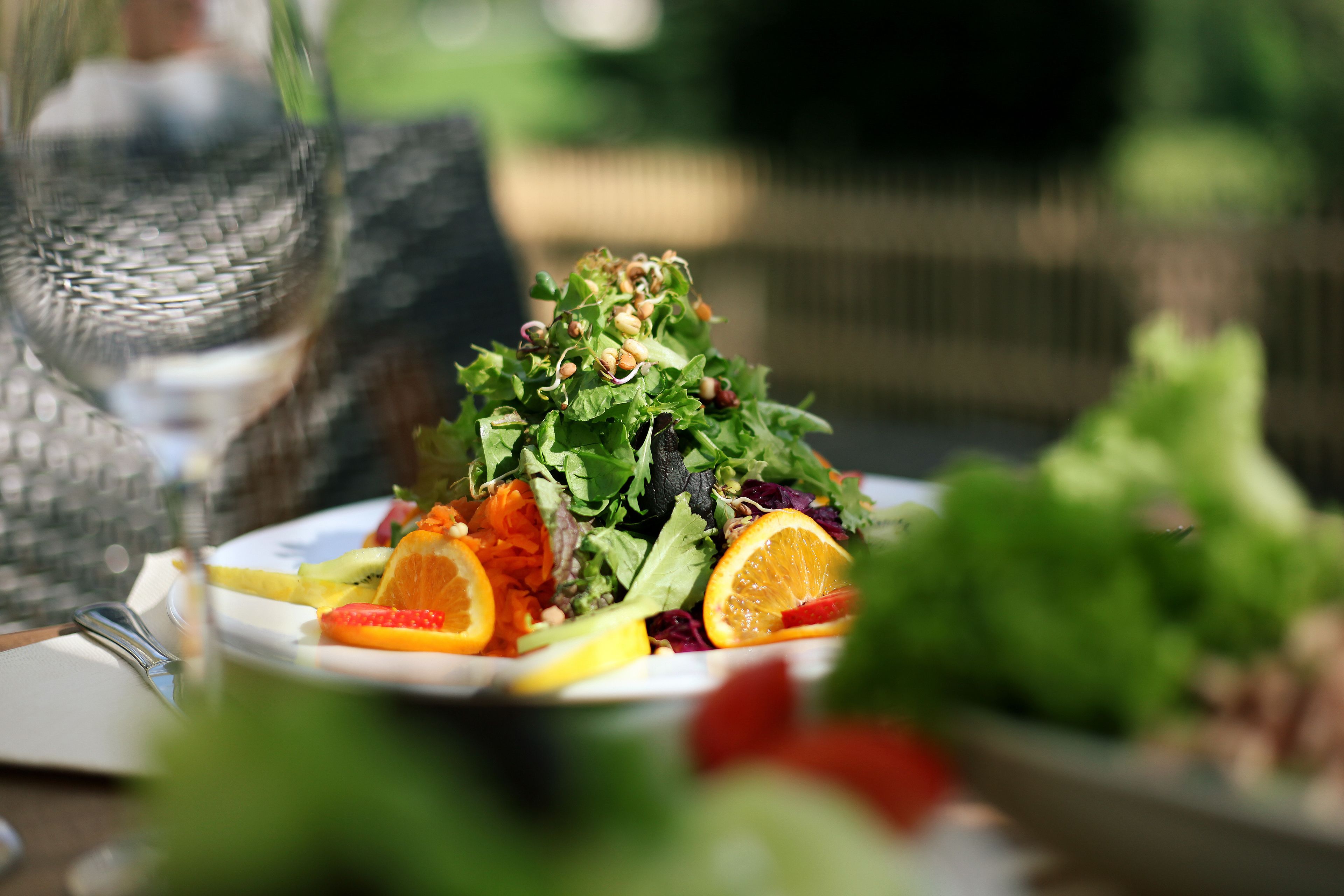 Un plato de ensalada con diversas verduras y frutas.