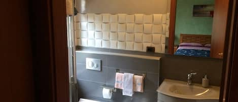 A modern bathroom with a bidet, a toilet, and a sink.