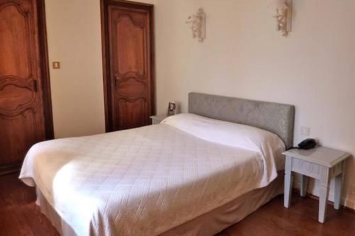 Een slaapkamer met een bed, een nachtkastje en twee deuren.