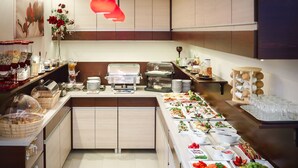 Een buffetopstelling met diverse foodstations, waaronder fruit, groenten en bereide gerechten.