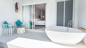A modern bathroom with a freestanding bathtub, a shower, and a glass door leading to a bedroom. - Dash Resort Langkawi (Langkawi)