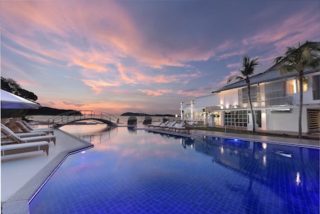 Una piscina al aire libre, sillones reclinables de piscina