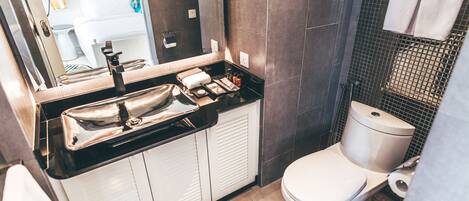 A modern bathroom with a black countertop, white sink, and a toilet.