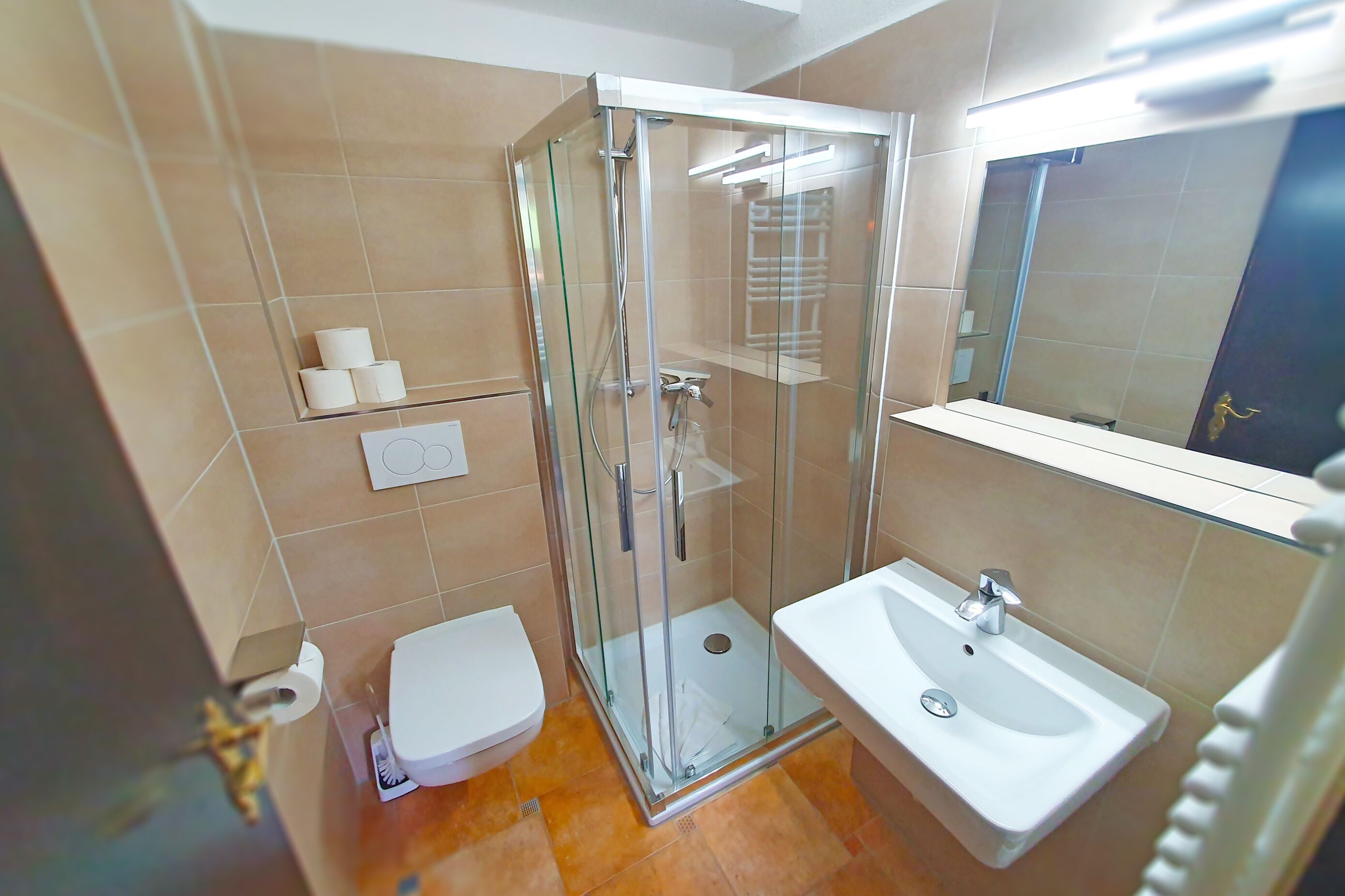 Une salle de bain avec une douche à parois de verre, des toilettes et un lavabo avec un miroir au-dessus.