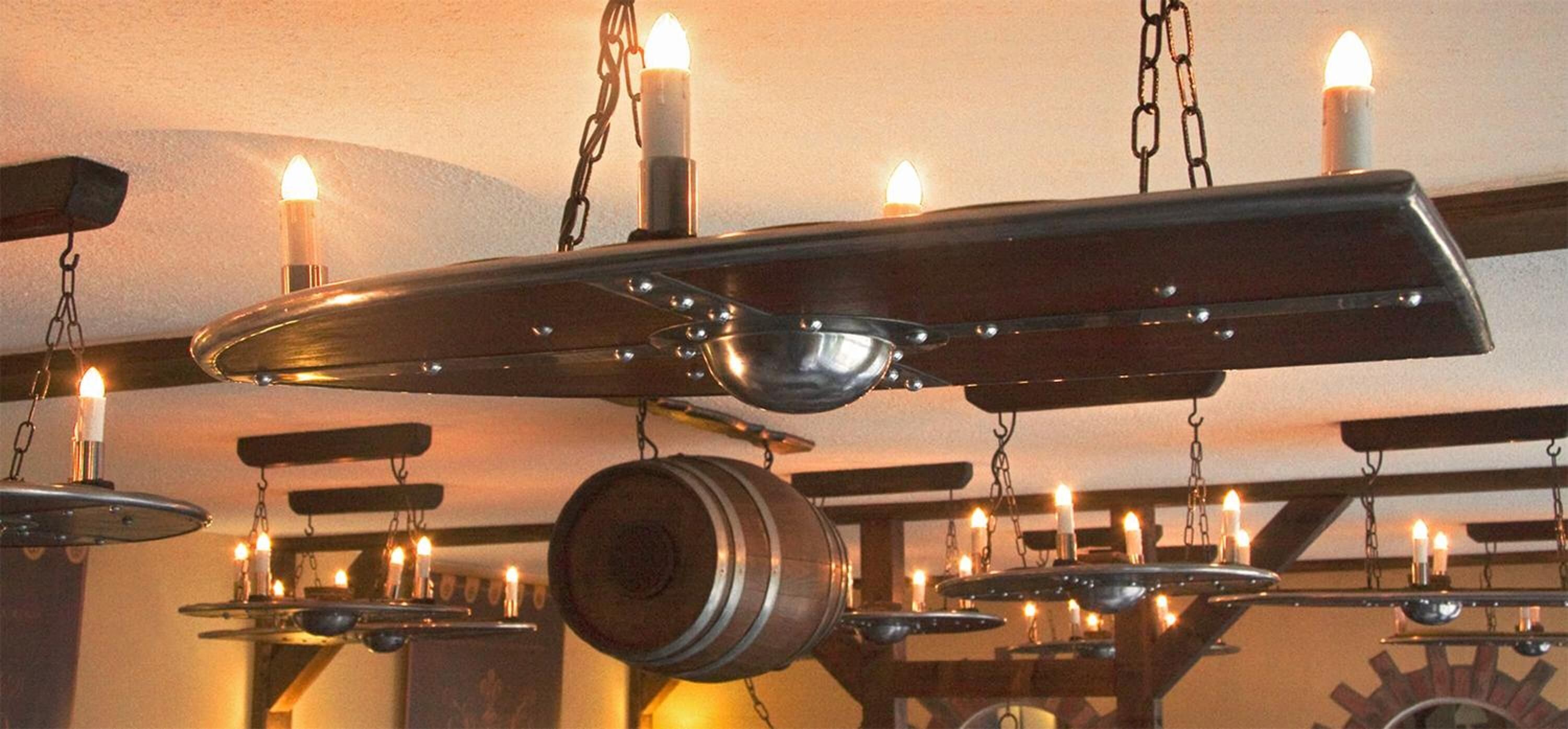 Un plafond orné de plusieurs lustres suspendus, chacun étant muni de bougies.