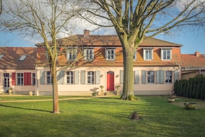 A two-story house with a red door, multiple windows, and a tiled roof. - Grafschaft Kloster Zinna (Jueterbog)