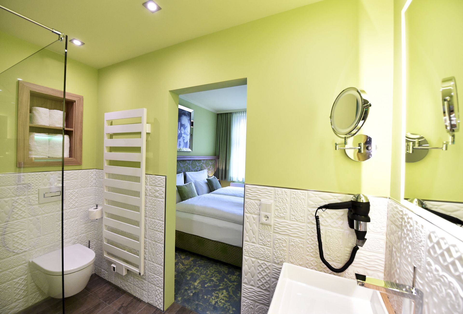 A hotel bathroom with a toilet, shower, and sink.