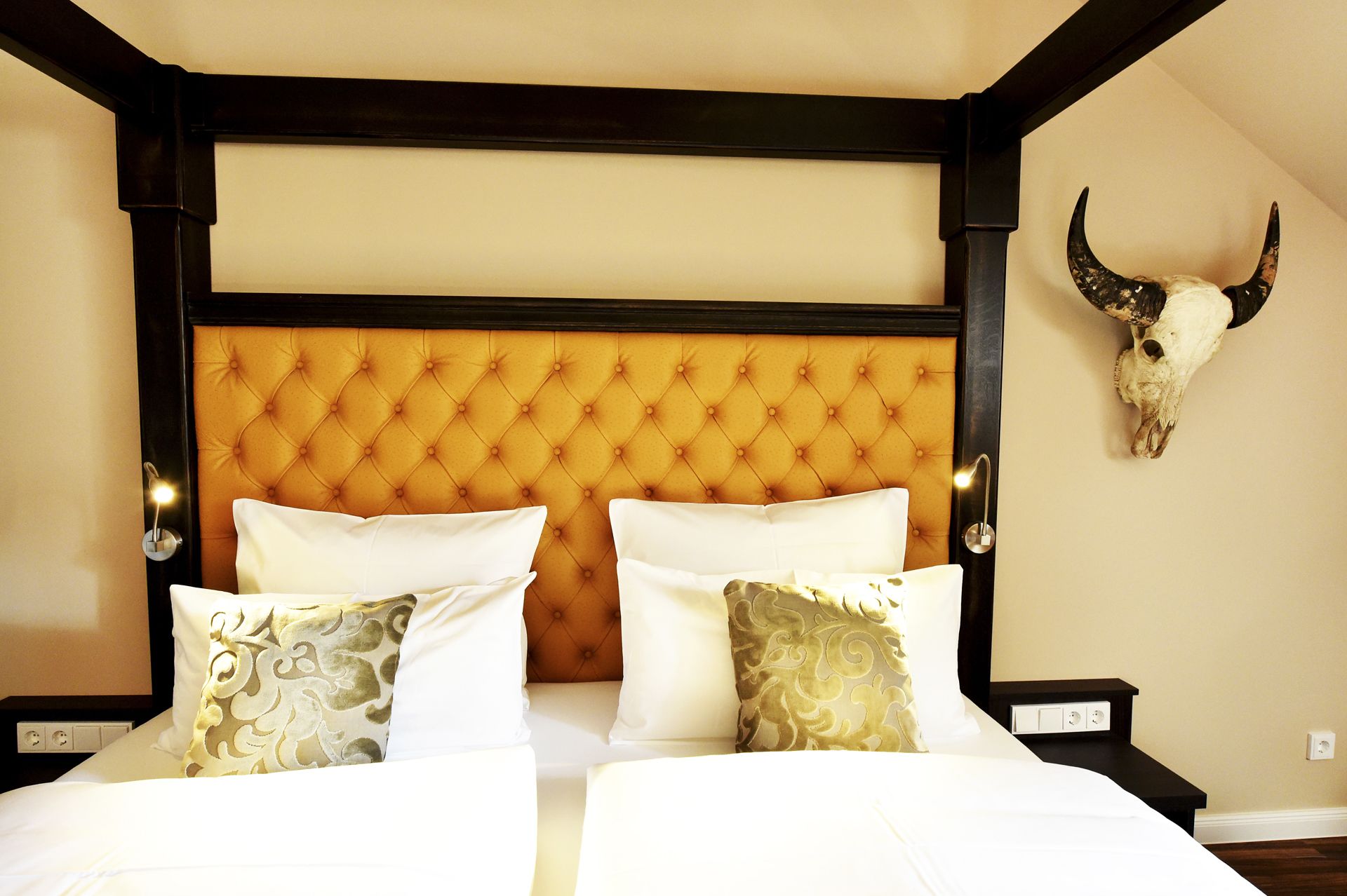 A bed with a tufted headboard, white bedding, and decorative pillows.
