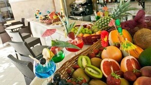 A bar area with a fruit display and a ceiling mural.