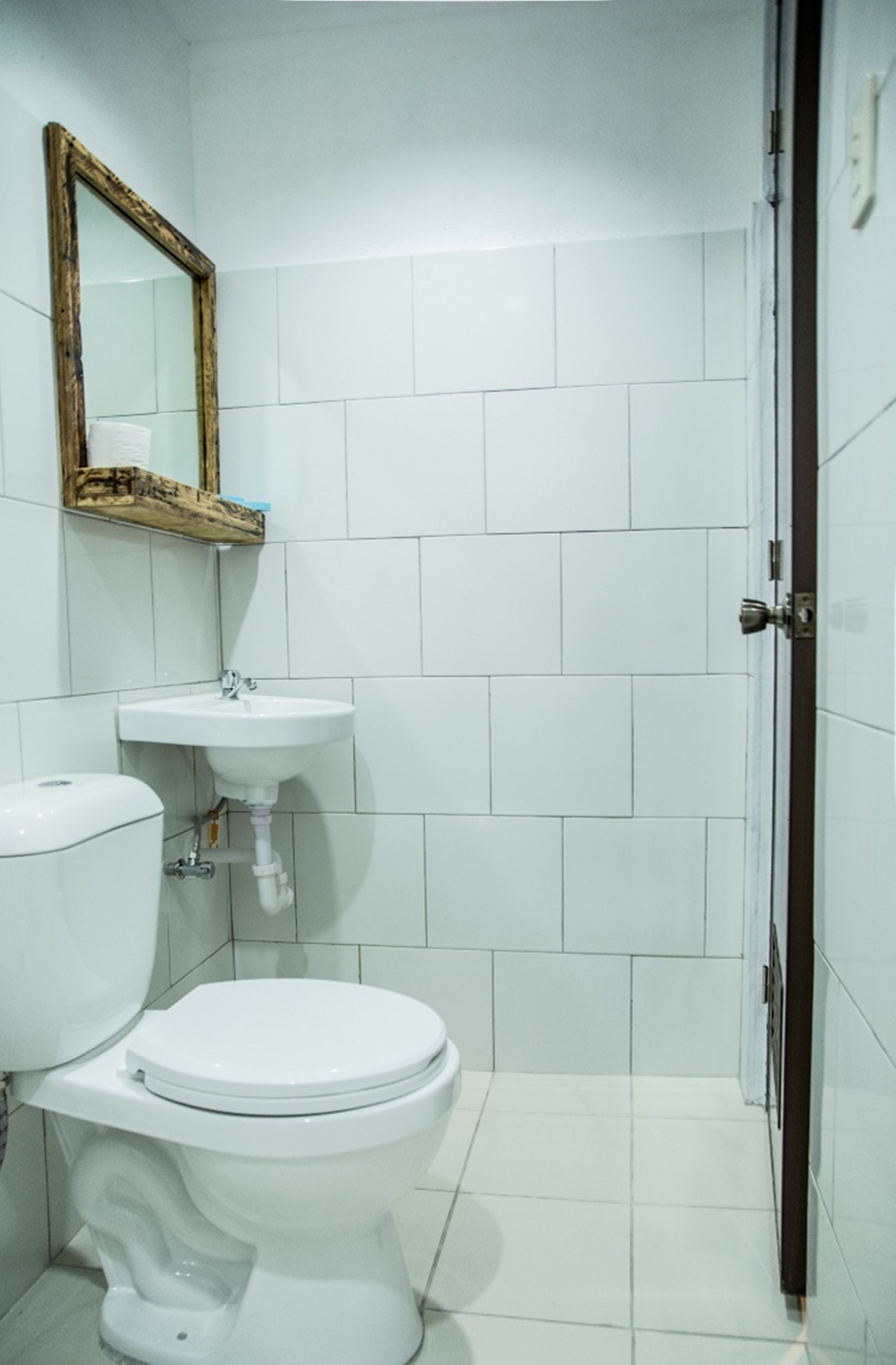 Un baño con inodoro, lavabo y espejo.