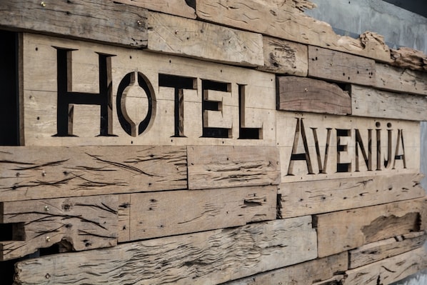 A wooden sign with the words "HOTEL AVENJA" carved into it.