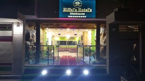The entrance of Eiffel's Hotel's Residences with a staircase leading up to the lobby, surrounded by stone walls and greenery. - Eifell's Hotel's (Abidjan)