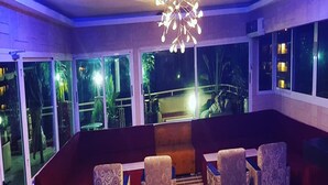 A modern lounge area with a patterned floor, a central seating arrangement, and large windows offering a view of the outdoors. - Eifell's Hotel's (Abidjan)