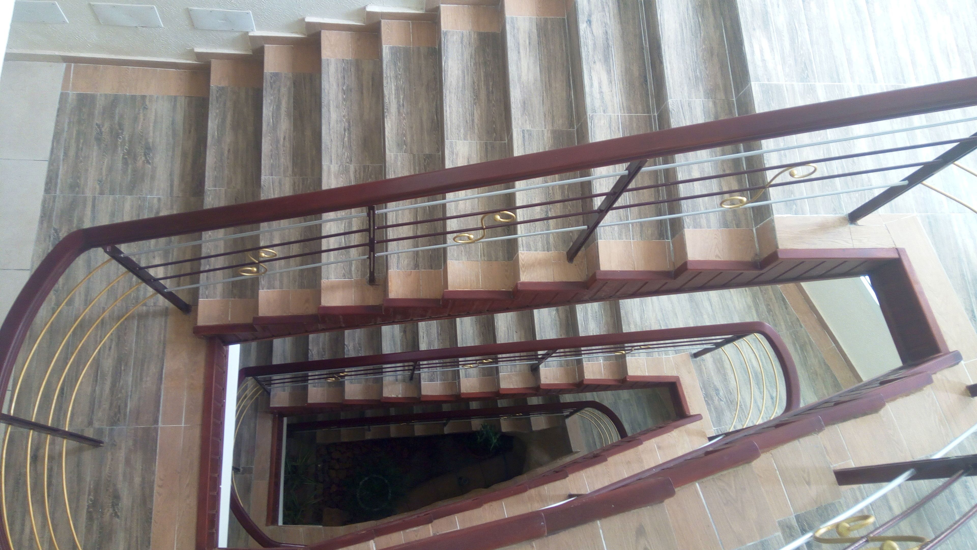 Un escalier en colimaçon avec des marches en bois et une rampe en métal.