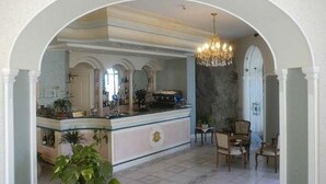 Een luxe keuken met een marmeren eiland, een elegante kroonluchter en klassiek meubilair.