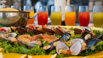 Un plateau de fruits de mer comprenant divers crustacés, accompagné d’une petite casserole.