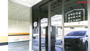 A motel entrance with a glass door, a welcome sign, and a sign indicating WIFI availability. - Ace Motel (Gangneung)