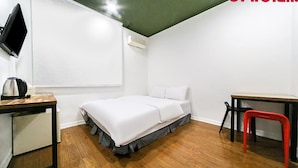 A small, modern room with a bed, a desk, and a chair. - Ace Motel (Gangneung)