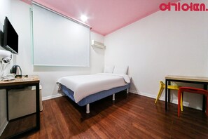 Un dormitorio con cama, escritorio, silla, televisión y aire acondicionado.