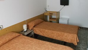 A room with two beds, a nightstand with a lamp, a small wooden table, and a wall-mounted TV. - Hotel Arce (San Pedro del Pinatar)