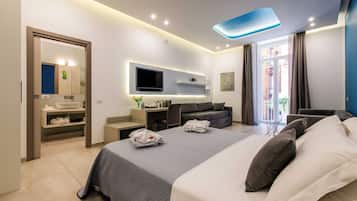 A modern hotel room with a large bed, a flat-screen TV, a desk, and a seating area.
