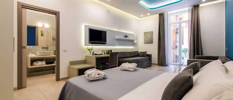 Habitació d'hotel moderna amb un llit gran, televisió de pantalla plana, escriptori i zona de seients.